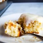 gluten free cinnamon rolls on a white plate with a fork