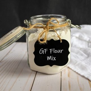 glass jar of gluten free flour mix sitting on a counter.