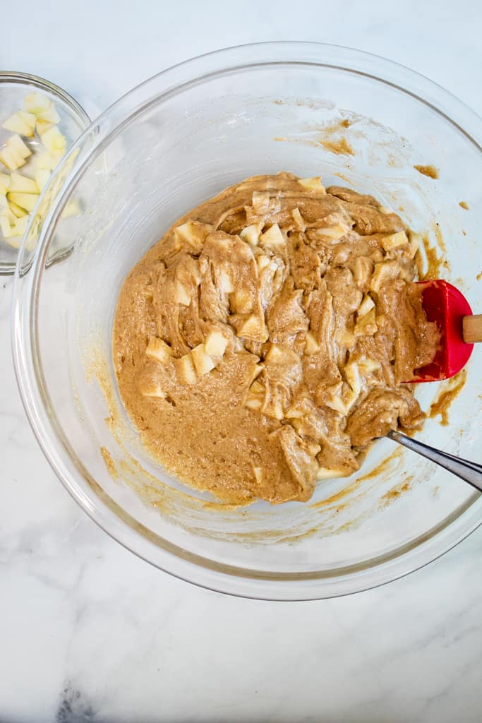 gluten free apple muffins mixed in a glass bowl