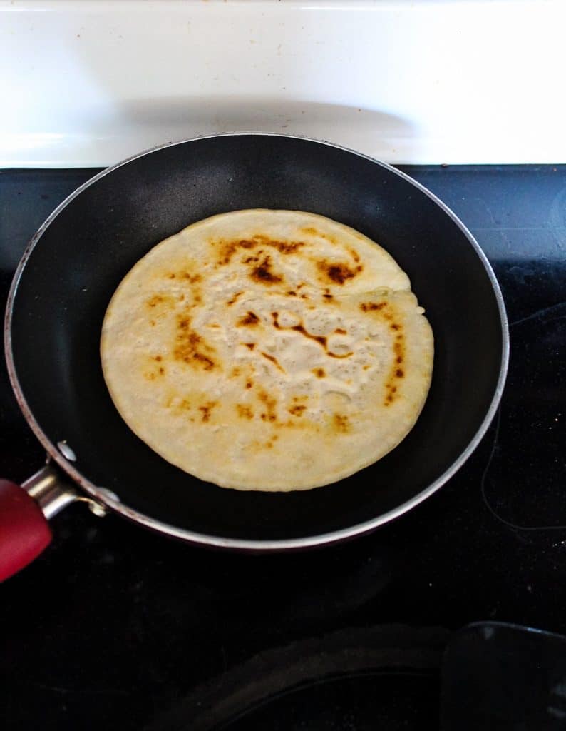 Cooked side of gluten free pita bread in a skillet