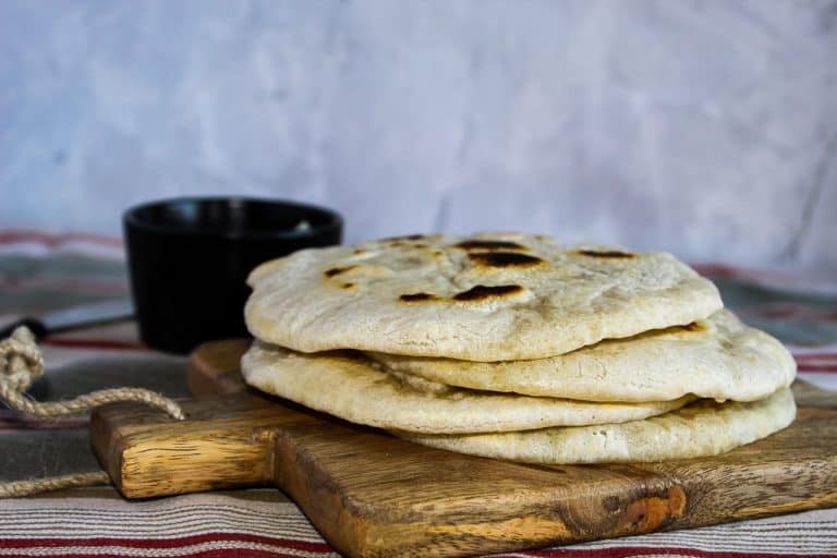 Stack of gluten free pita breads on a wooden serving board