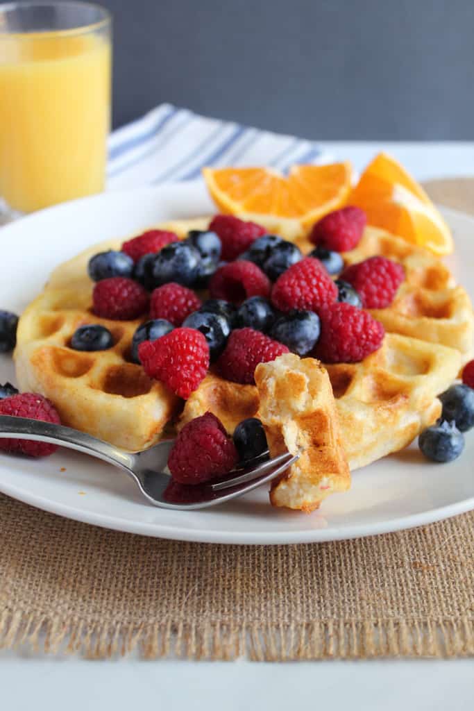 gluten free belgian waffles on a white plate with fruit