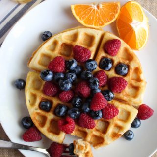 gluten free belgian waffles on a white plate with fruit