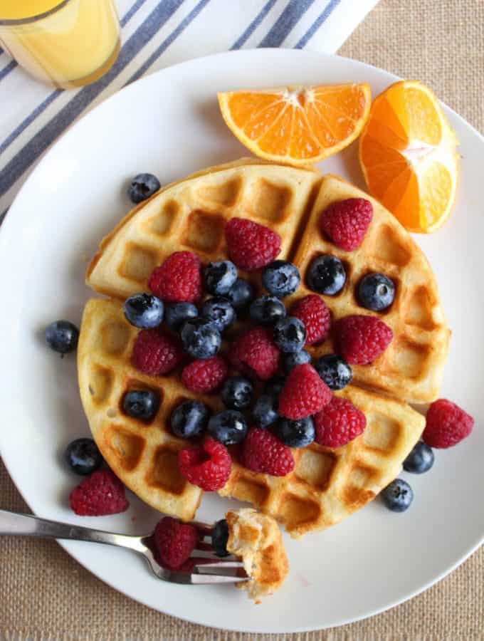 gluten free belgian waffles on a white plate with fruit