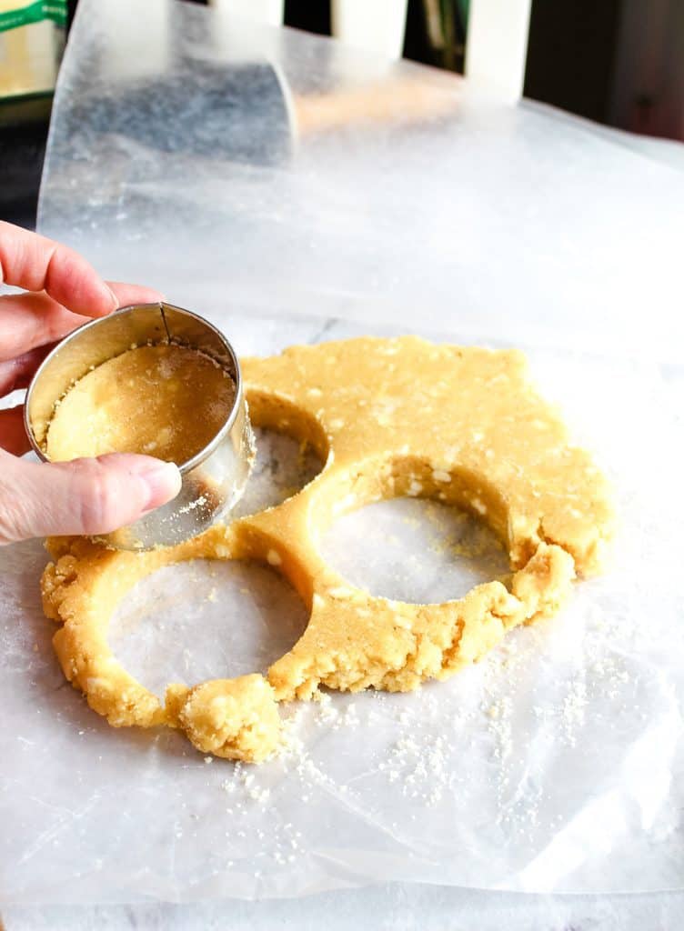 Biscuits being cut with a cookie cutter