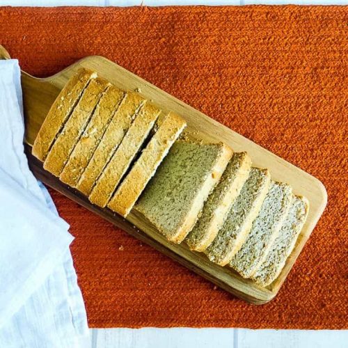 gluten free vegan sandwich bread on a cutting board on an orange towel