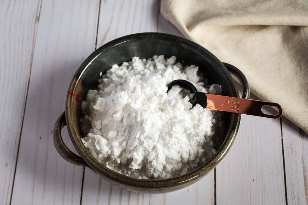 bowl of potato starch sitting on a white countertop.