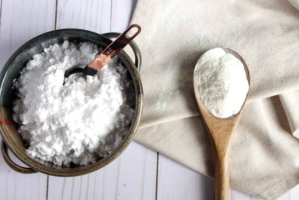 potato starch in a bowl next to potato flour in a spoon.