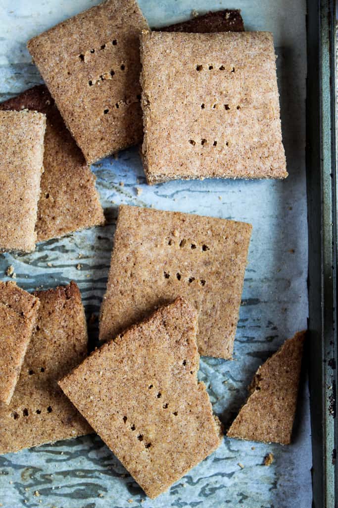 low carb gluten free graham crackers broken apart on a baking pan.