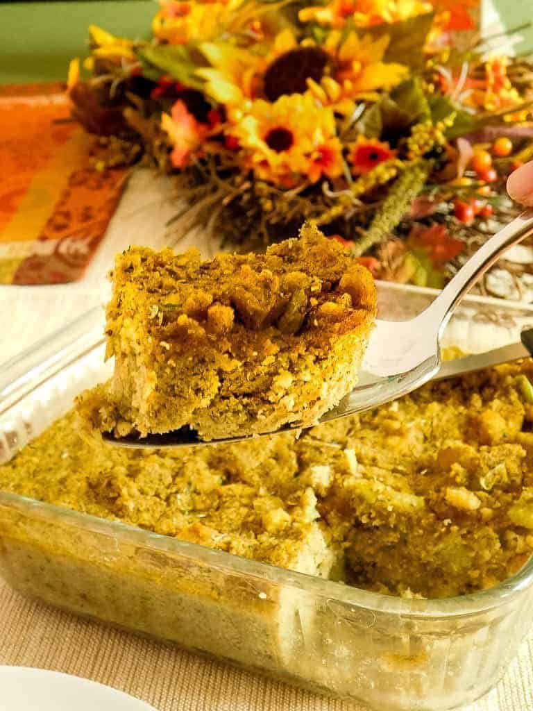 cornbread dressing sliced from the pan on a silver serving spoon