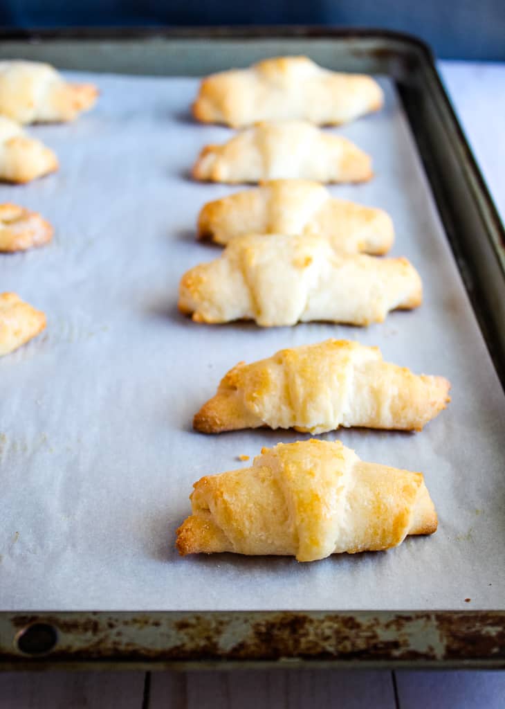 Gluten free crescent rolls baked sitting on a baking pan