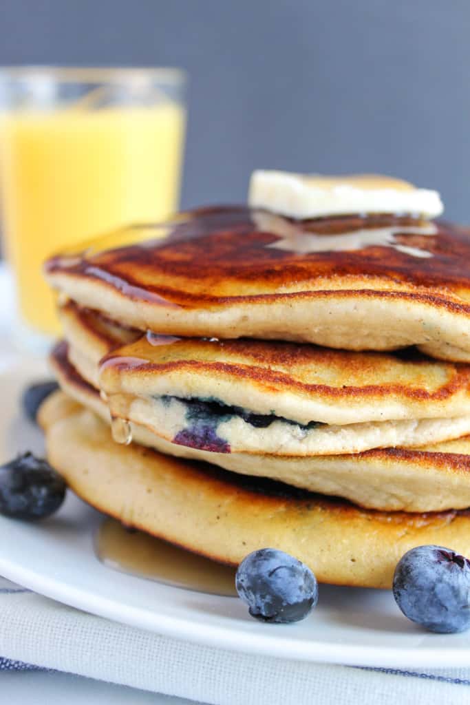 gluten free blueberry pancakes stacked on a white plate