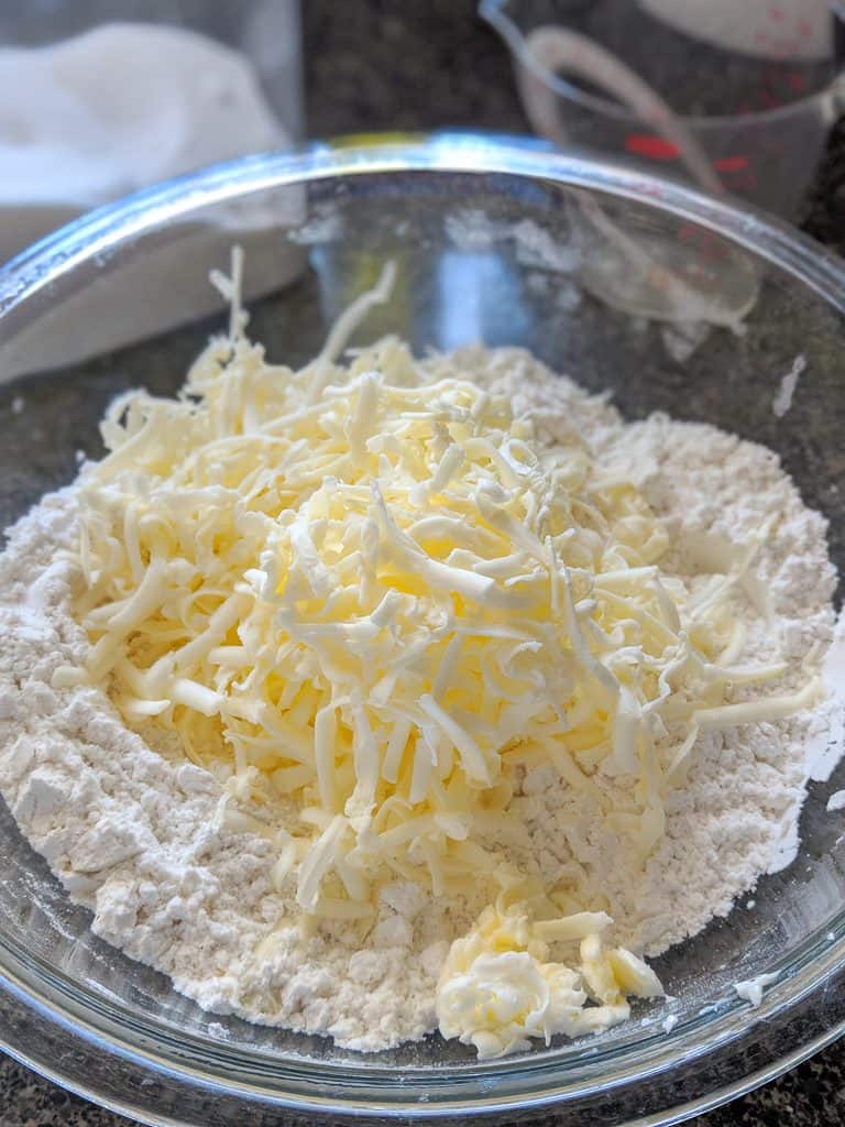 grated butter into biscuit flour in a glass bowl