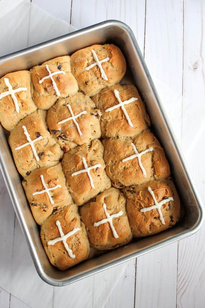 gluten free hot cross buns in a baking pan sitting on a countertop