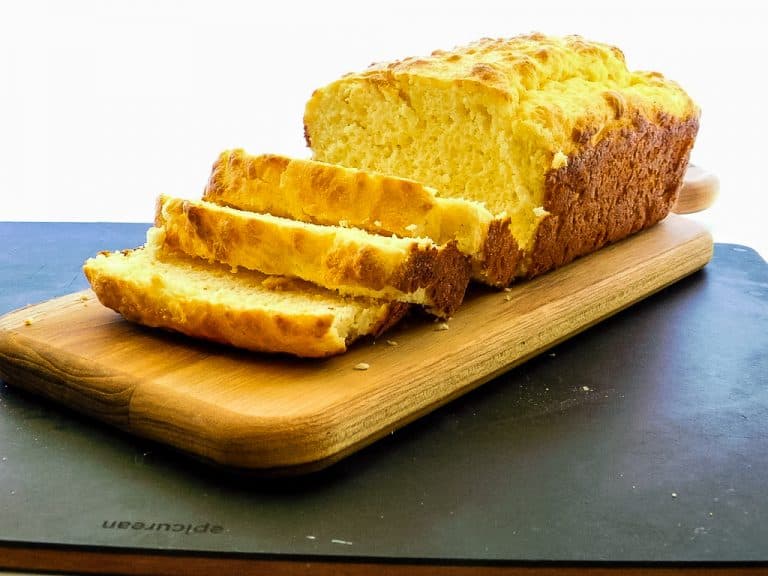 sliced loaf of low carb bread on a black cutting board