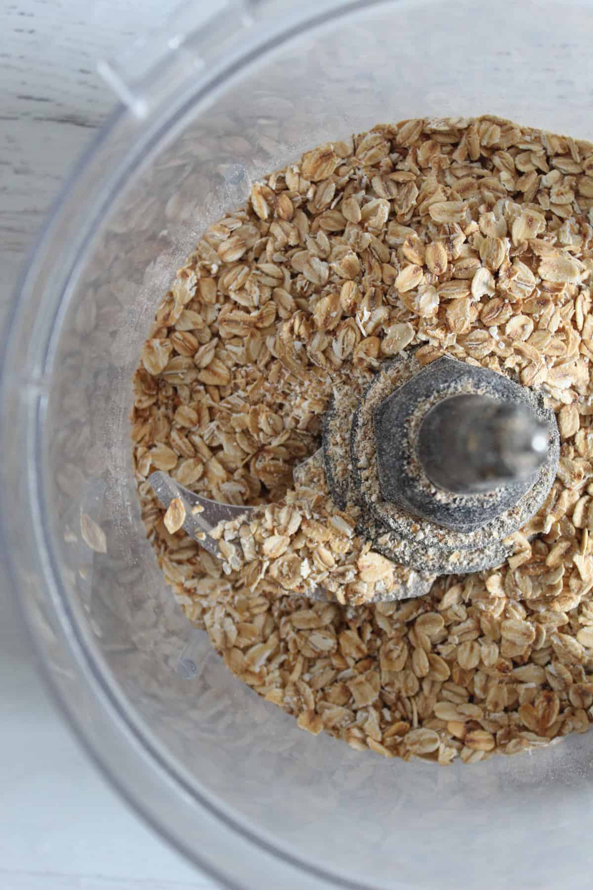 adding toasted oats to a food processor
