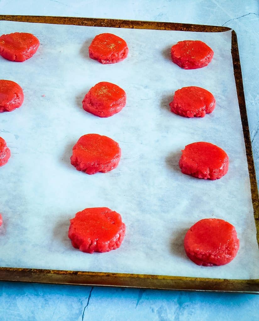 pink cookies on a cookie sheet