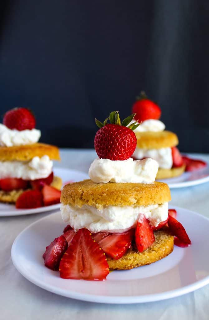 side shot of Gluten free strawberry shortcakes on a white plate ready to eat