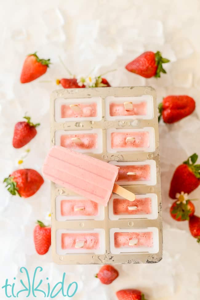 strawberries and cream popsicles on a white counter