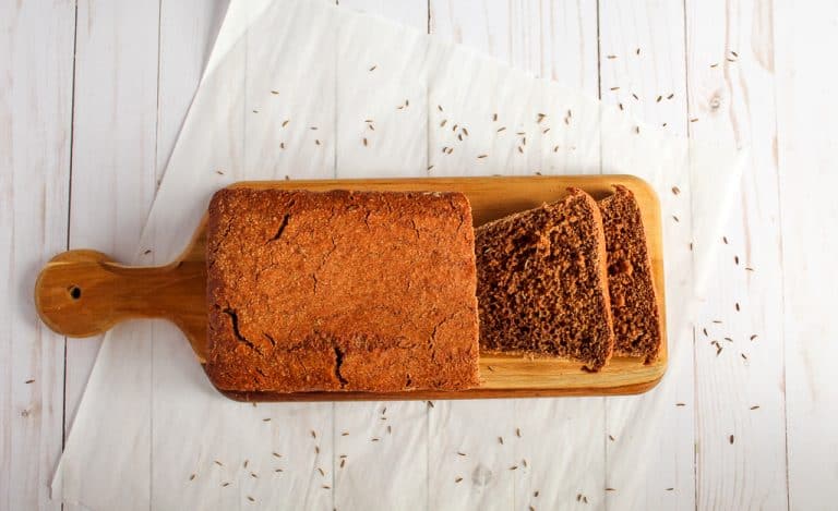 Gluten free pumpernickel bread on a wooden board for serving