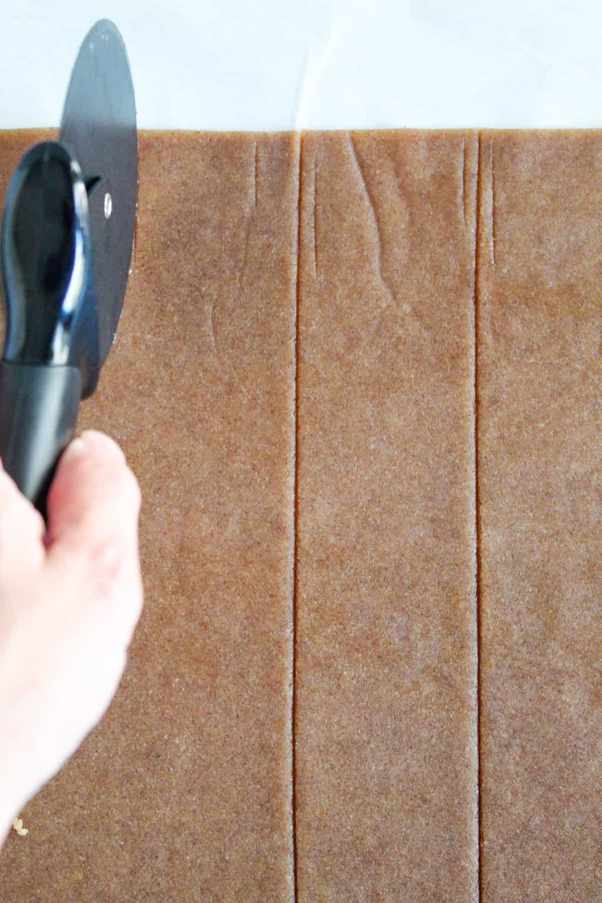 using a pizza cutter on graham cracker dough