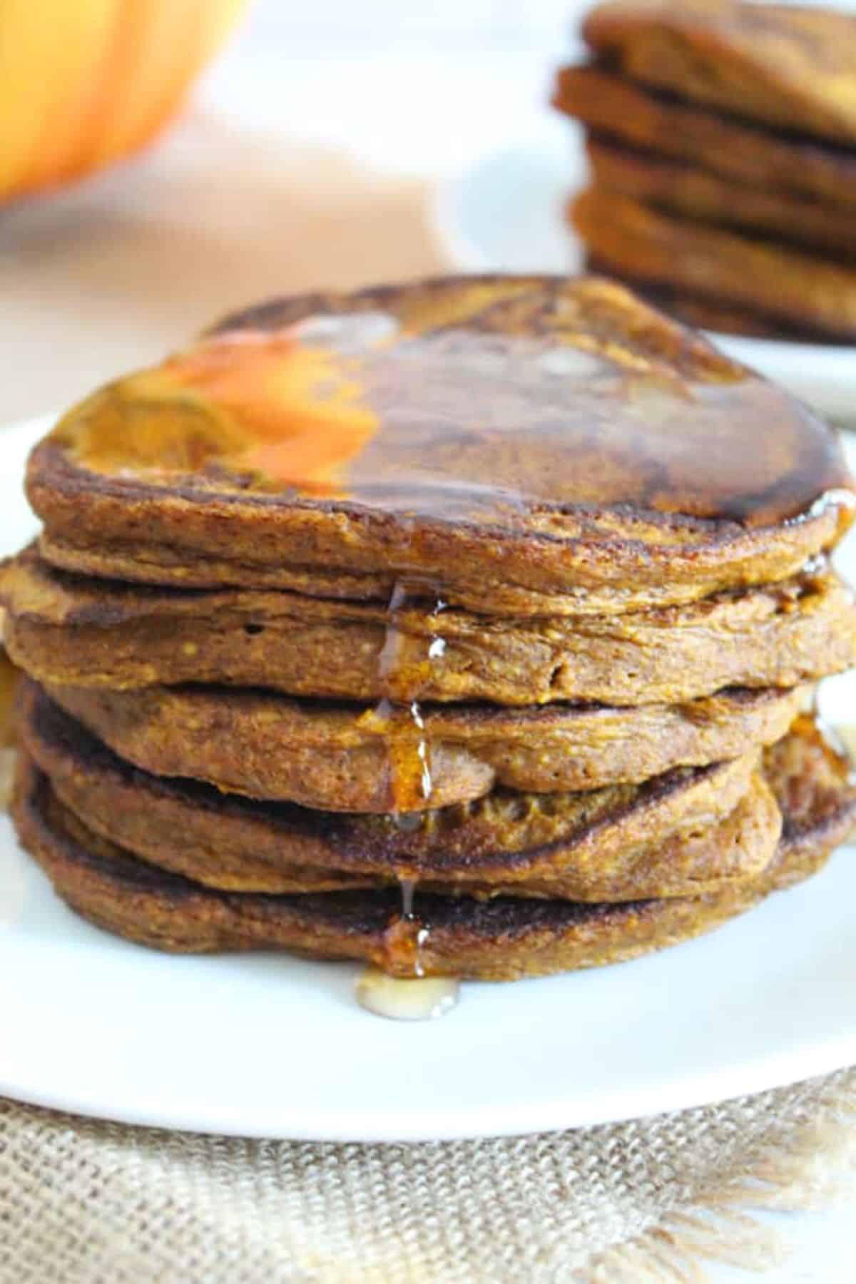 syrup dripping off a stack of pumpkin pancakes