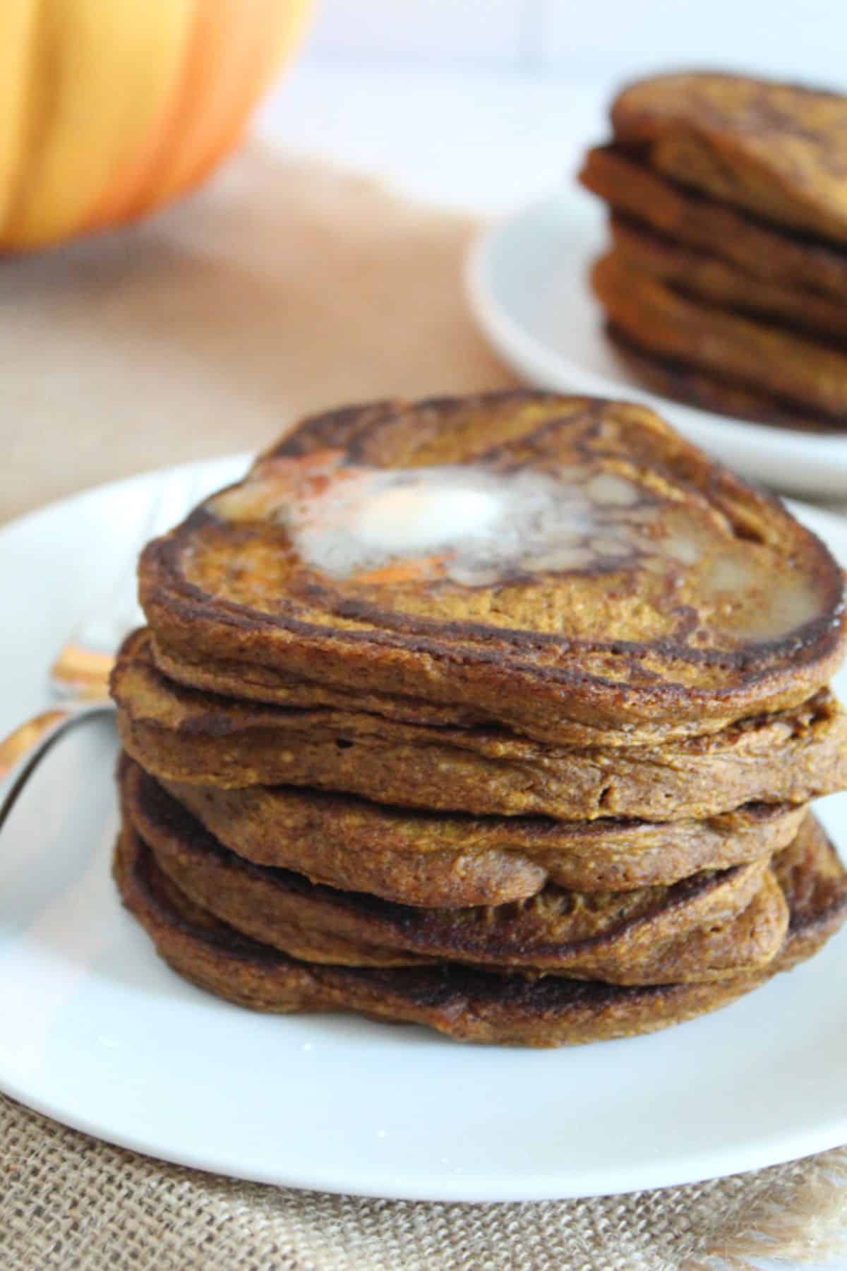 stack of pumpkin pancakes with melted butter