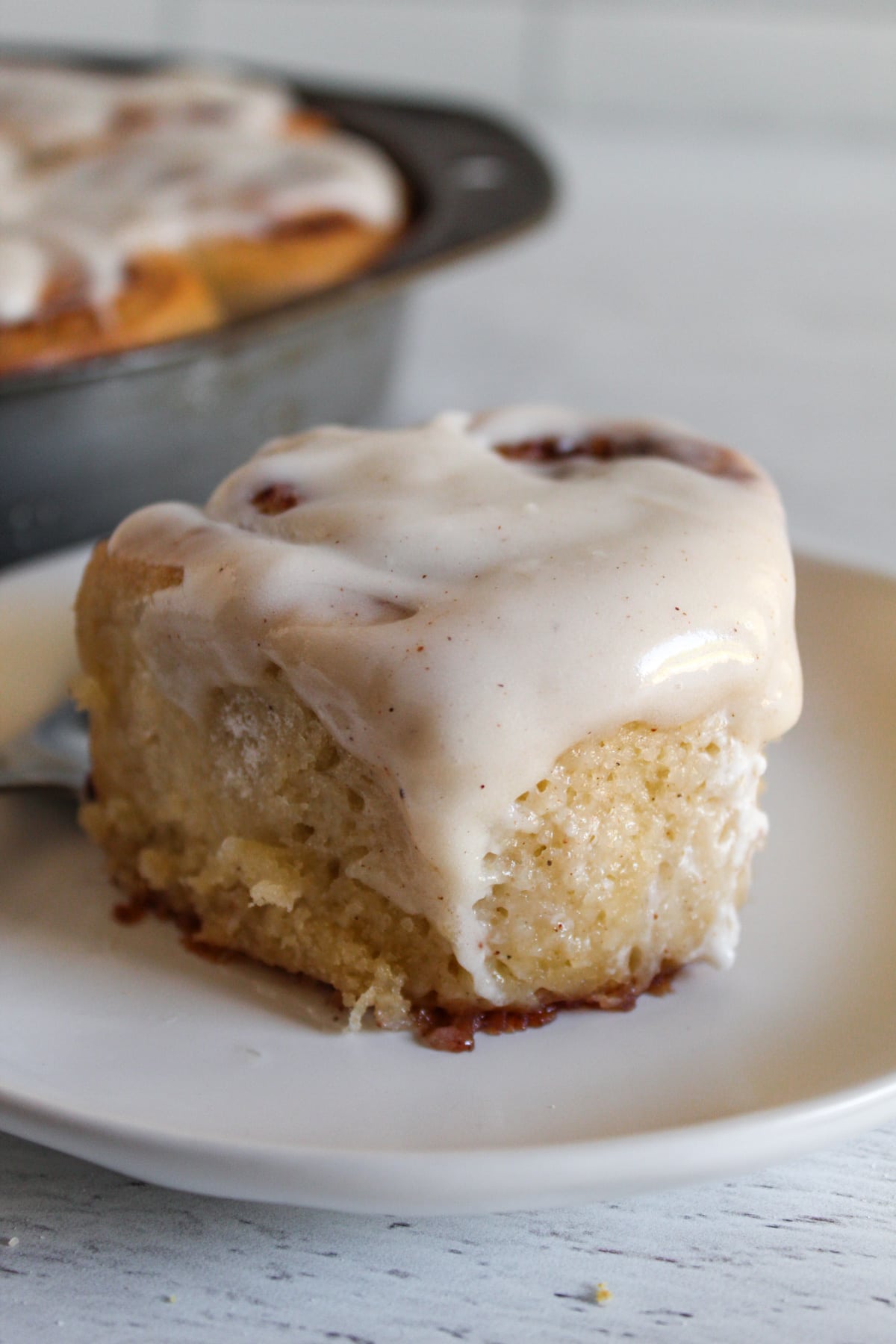 baked cinnamon roll drizzled with frosting