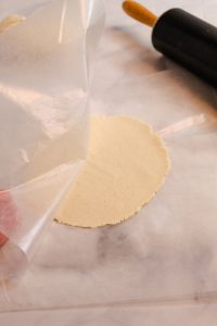 peeling wax paper off a cassava flour tortilla