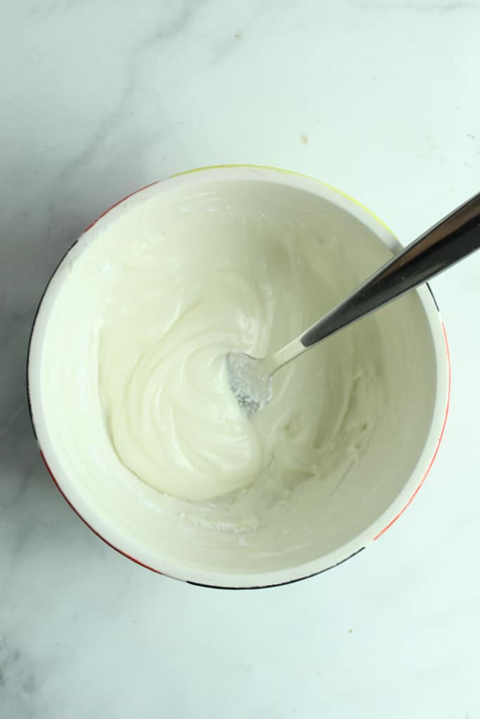 gluten free icing in white bowl with spoon
