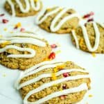 vertical image of gluten free cranberry cookies with icing drizzled over the top