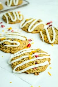 vertical image of gluten free cranberry cookies with icing drizzled over the top