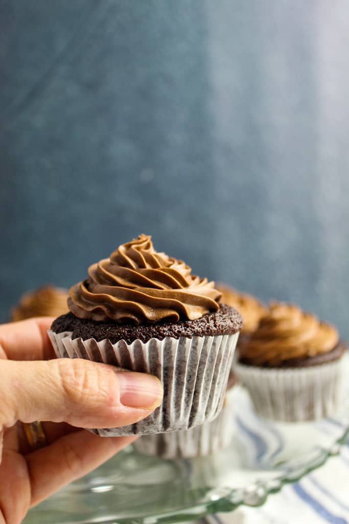 side shot of a hand holding a cupcake