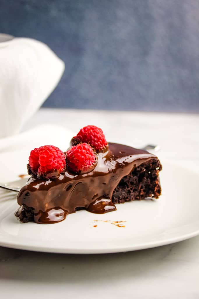 slice of flourless chocolate cake topped with raspberries