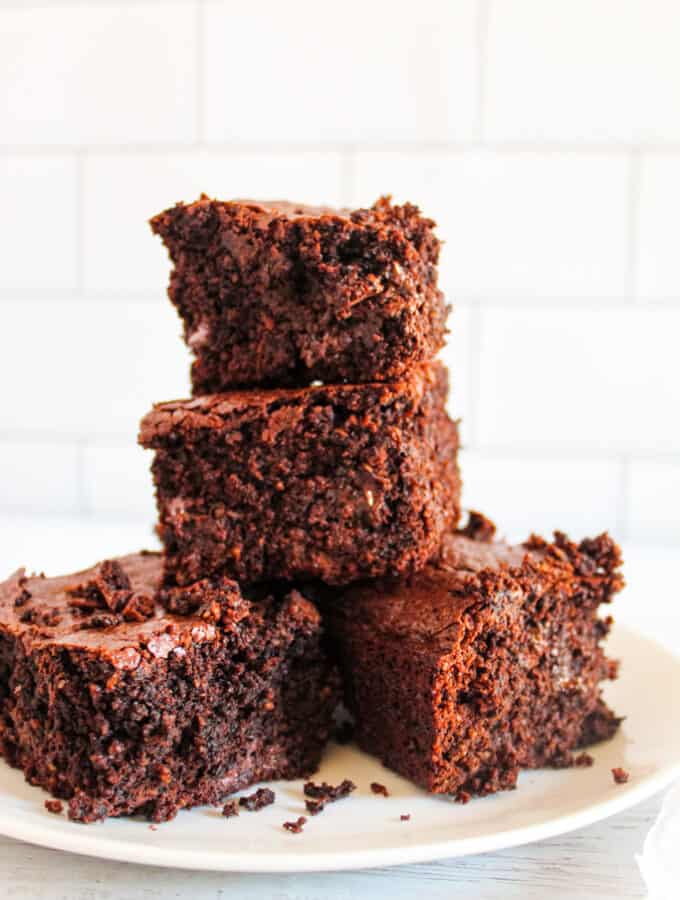4 stacked oat flour brownies on a white plate