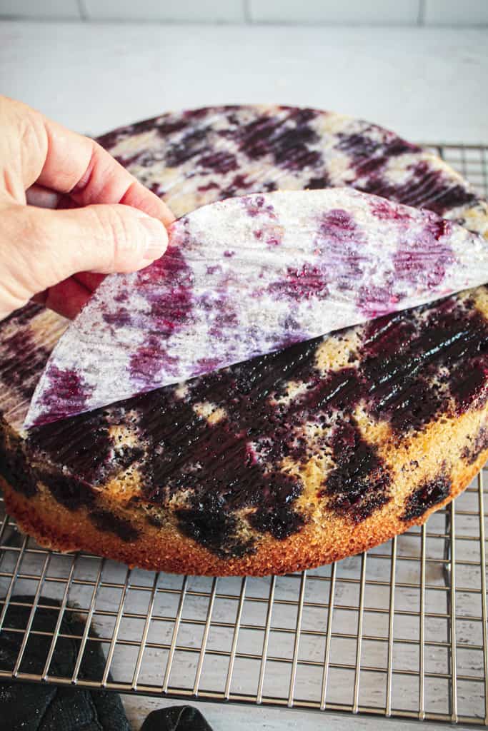 peeling parchment off baked blueberry cake