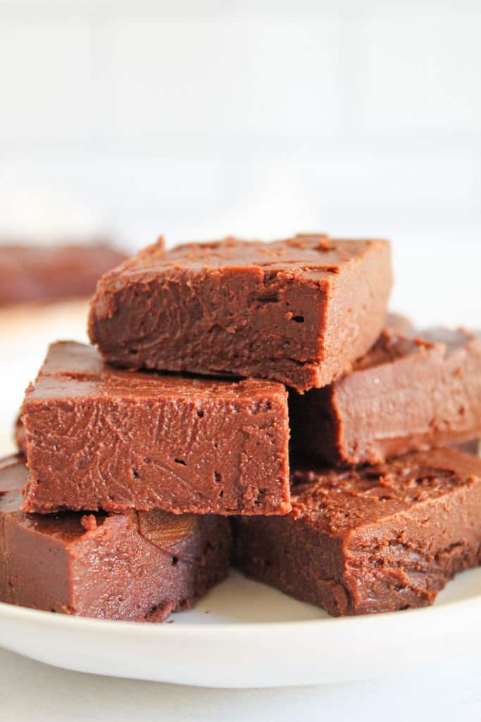 pieces of fudge stacked on a white plate.