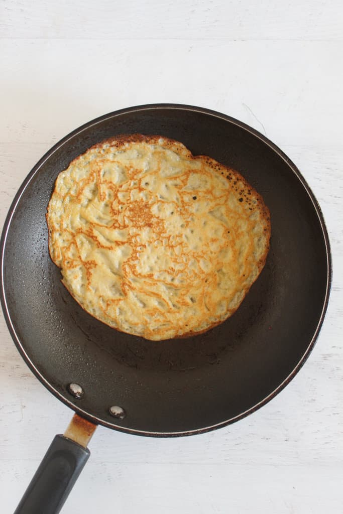 skillet with a cooked crepe.