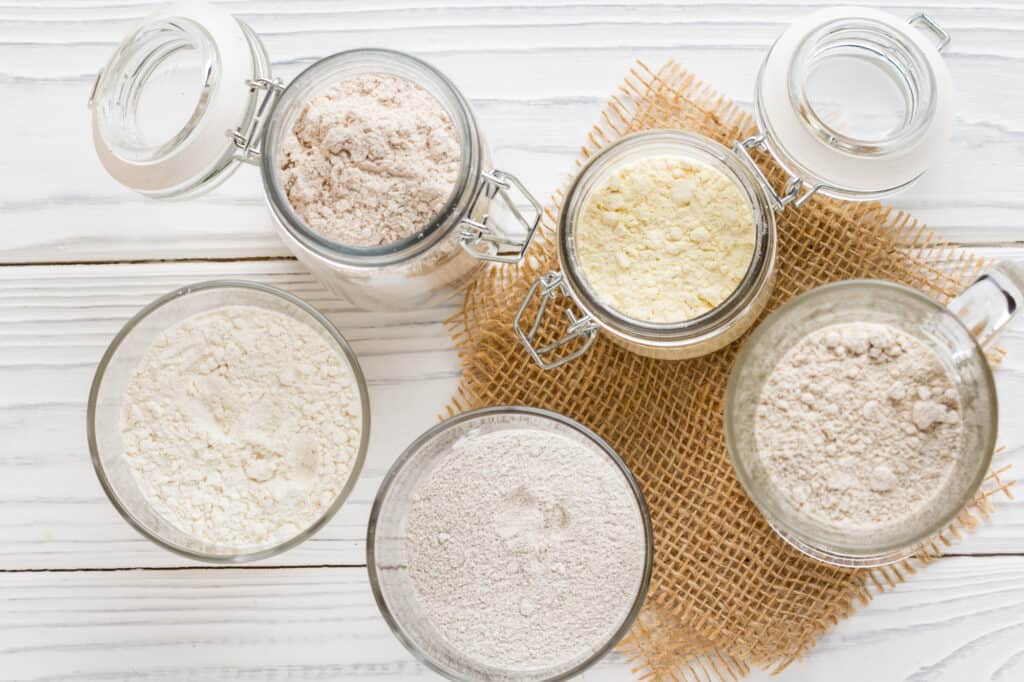 assortment of flours on a white counter.