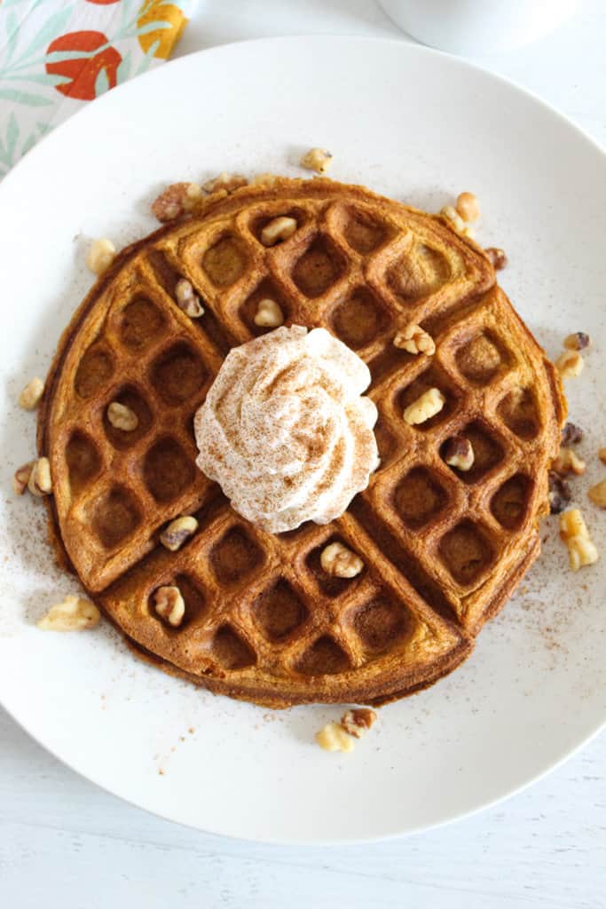 overhead shot of waffle on a white plate.