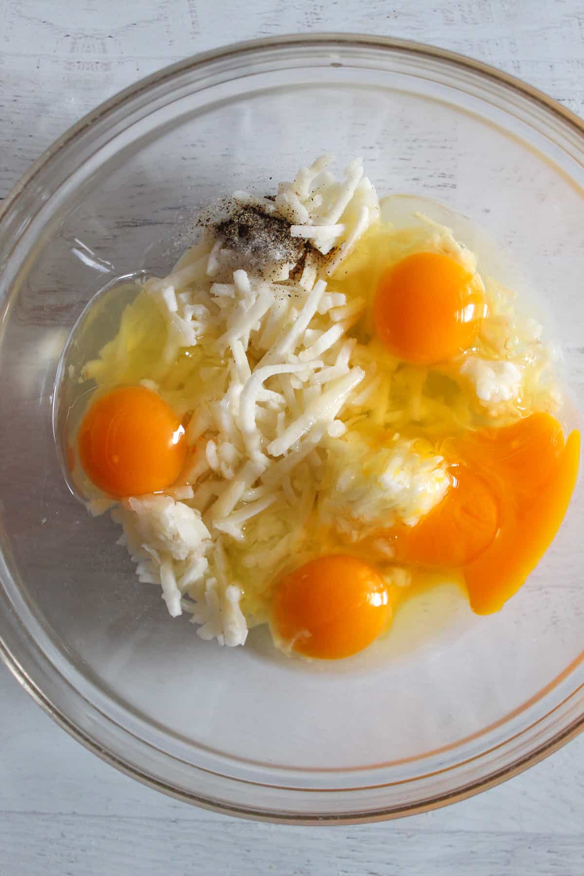 egg, hash browns and milk in a glass bowl.