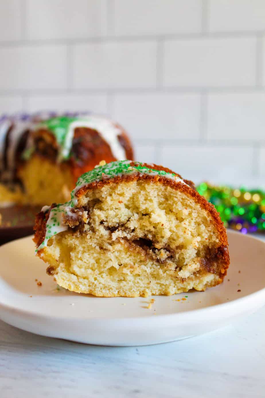 slice of gluten-free king cake on a white plate.