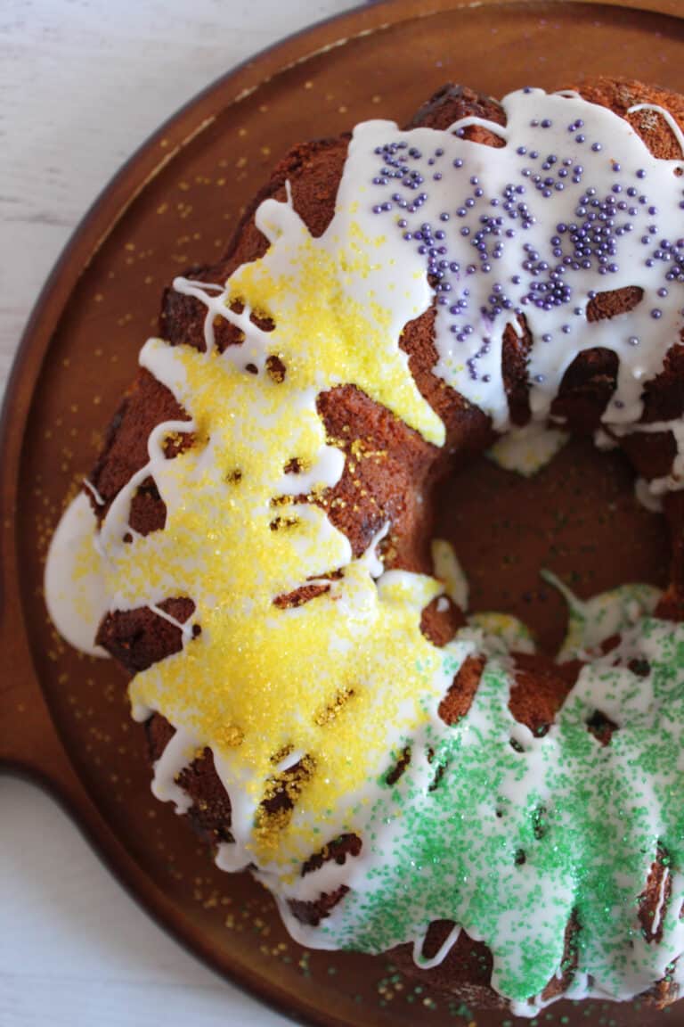 king cake sitting on a brown plate, overhead shot.