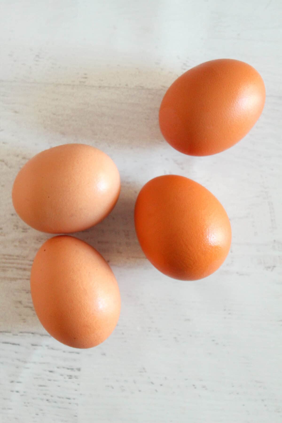 4 brown eggs on a countertop.