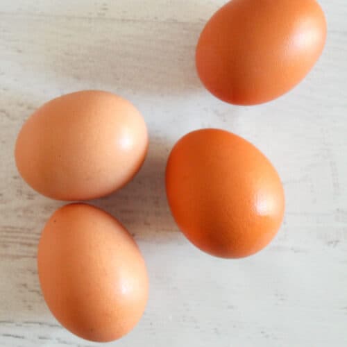 4 brown eggs on a countertop.