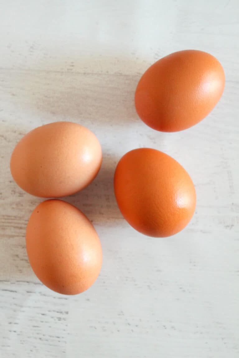 4 brown eggs on a countertop.