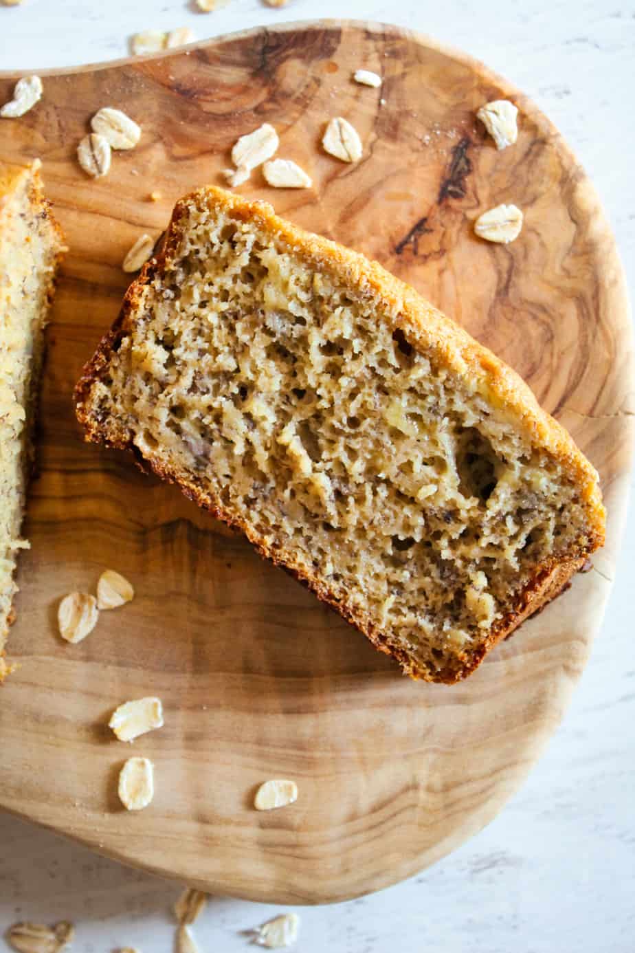 slice of oat flour banana bread on a cutting board.