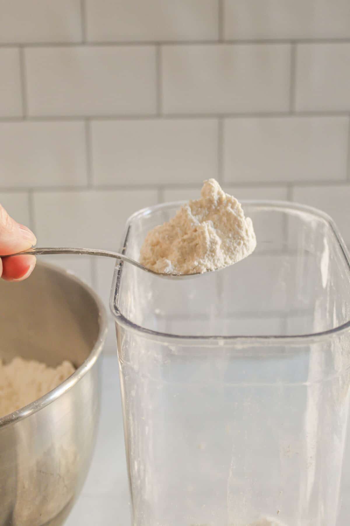 spooning gluten free flour into a container.