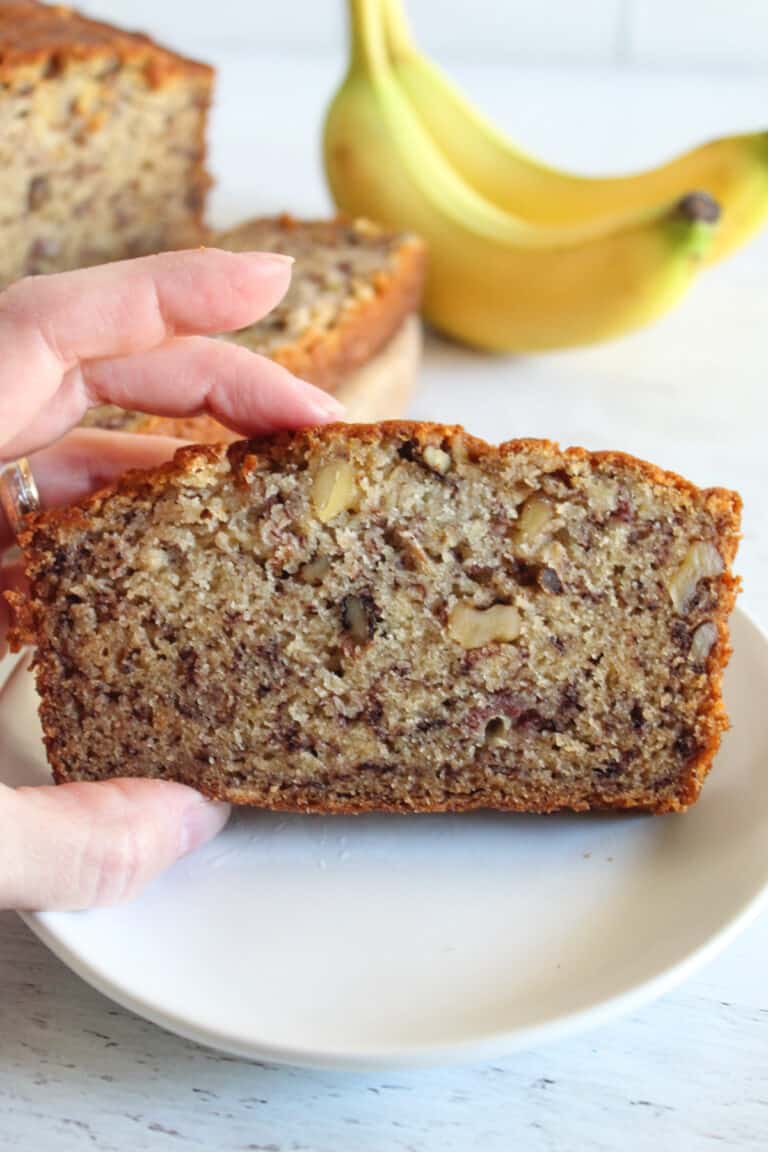 slice of gluten free banana bread on a white plate.