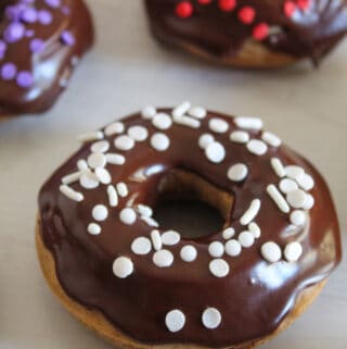 gluten free donut with chocolate glaze and white sprinkles.